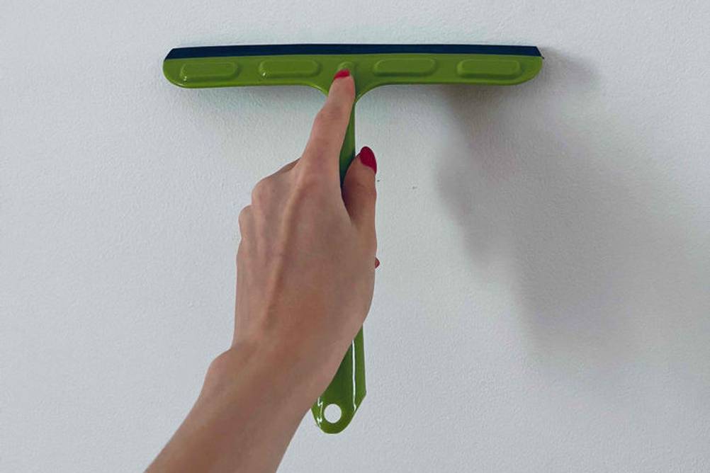 Fensterputzer getestet: grüner Fensterputzer vor einer weißen Wand.