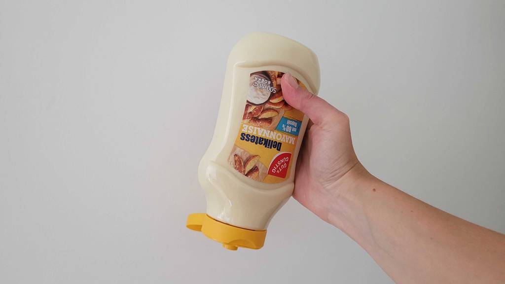 Mayonnaise im Test: Eine Hand hält die Flasche mit offenem Deckel nach unten