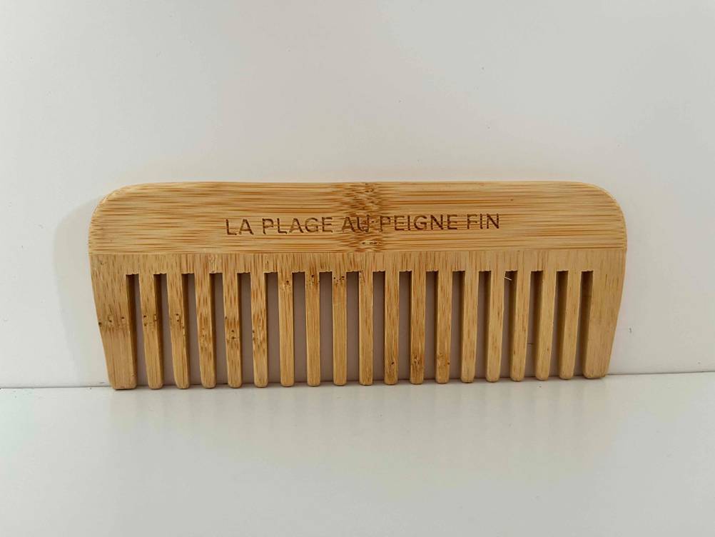 Kamm getestet: Ein Holzkamm steht auf seinen Zinken auf heller Oberfläche