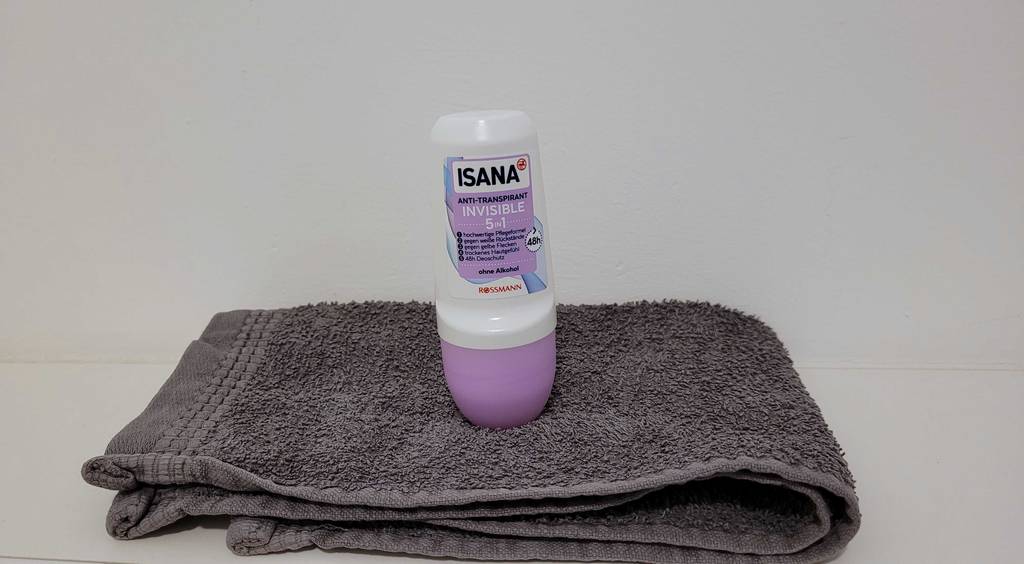 Antitranspirant im Test: Antitranspirant-Roller der Marke Isana steht auf einem grauen Handtuch.