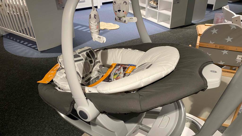 Elektrische-Babyschaukel getetest: eine elektrische-Babyschaukel mit Plüschtieren nach unten hängend.