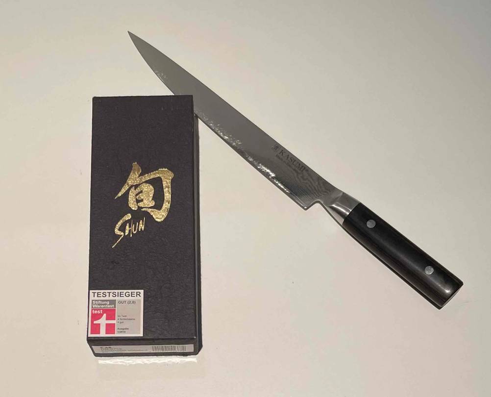Schleifstein getestet: Eine Verpackung neben einem Messer auf einer hellen Oberfläche.