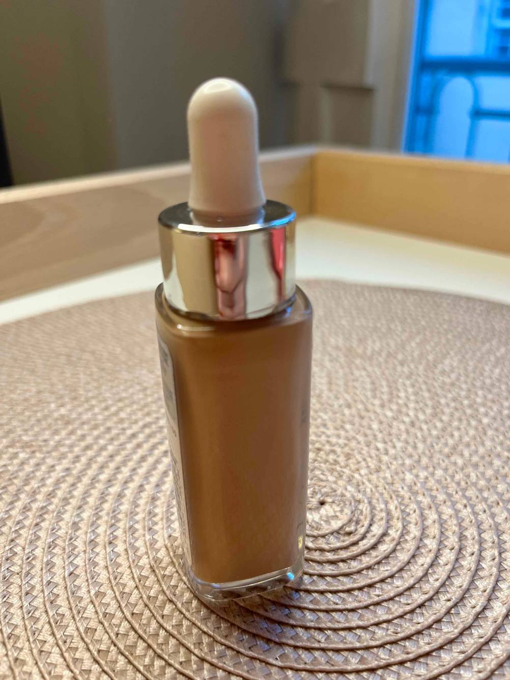 Make-up getestet: Eine Flasche von der Seite auf einem beigen Untergrund.