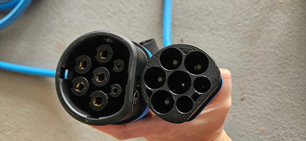 E-Auto-Ladekabel getestet: Eine Hand hält die zwei unterschiedlichen Steckerarten hoch.