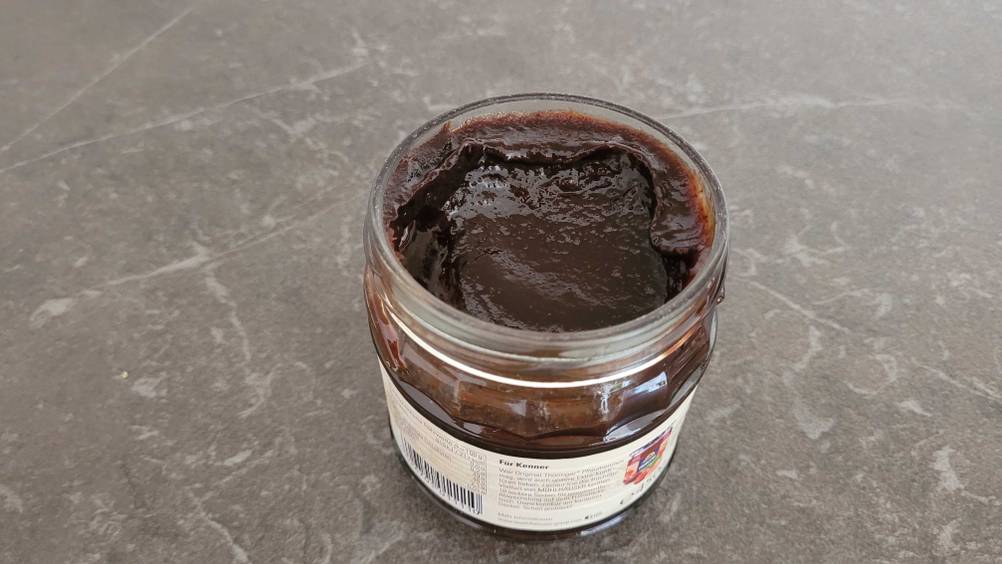 Pflaumenmus-Test: Ein geöffnetes Glas auf einer dunklen Fläche.