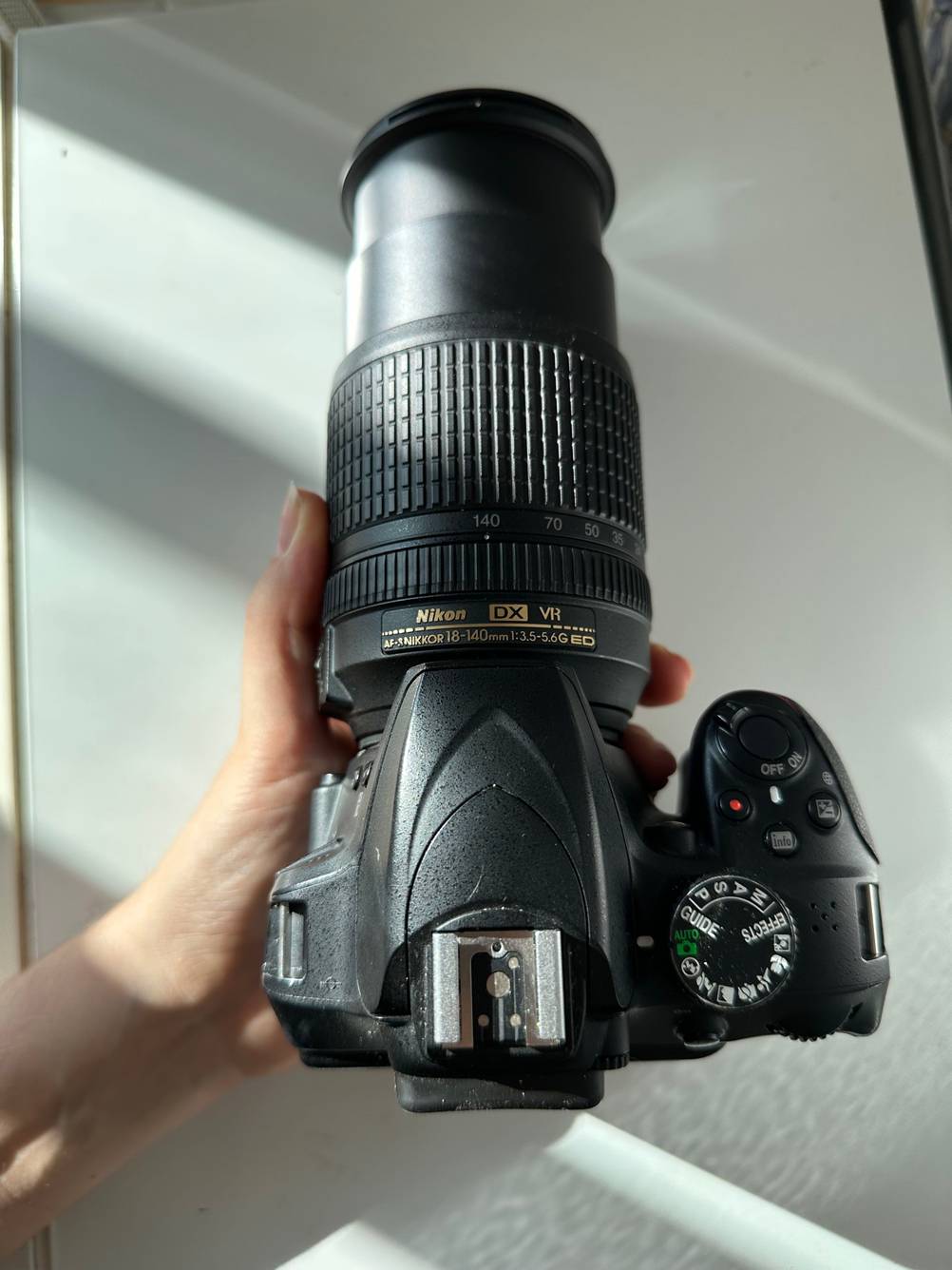 Nikon-Objektiv getestet: Eine Hand hält eine Kamera mit einem angeschlossenen Objektiv vor einer helle Fläche.