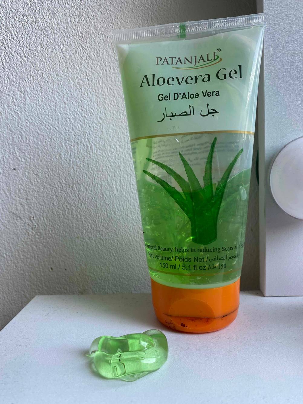 Aloe-Vera-Gel-Test: ein Klecks Aloe-Vera-Gel neben stehender Verpackung.
