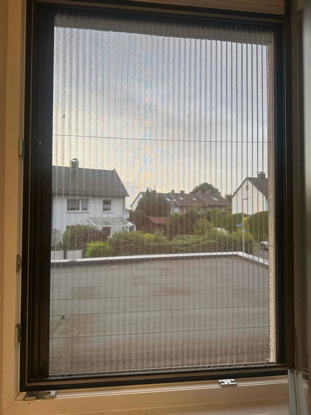 Eine geschlossene, getestete Insektenschutzrollo, die in einem Fenster befestigt ist.