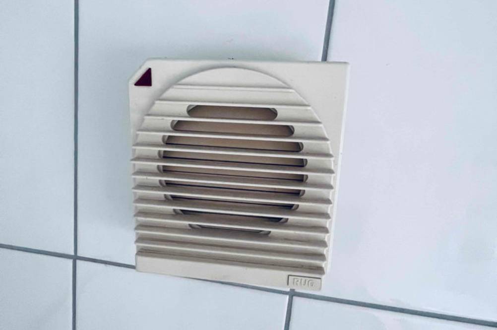 Badlüfter getestet: An einer Fließenwand befindet sich ein Gerät montiert.