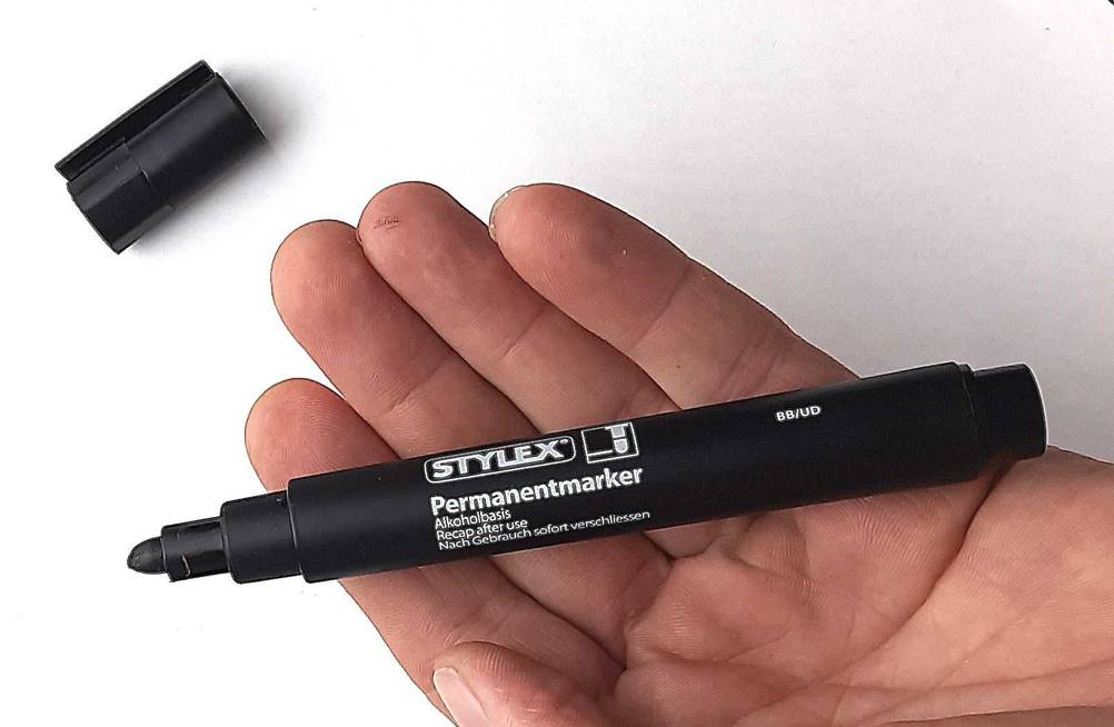 Der geöffnete Permanent-Marker, der getestet wurde liegt in einer Handfläche.