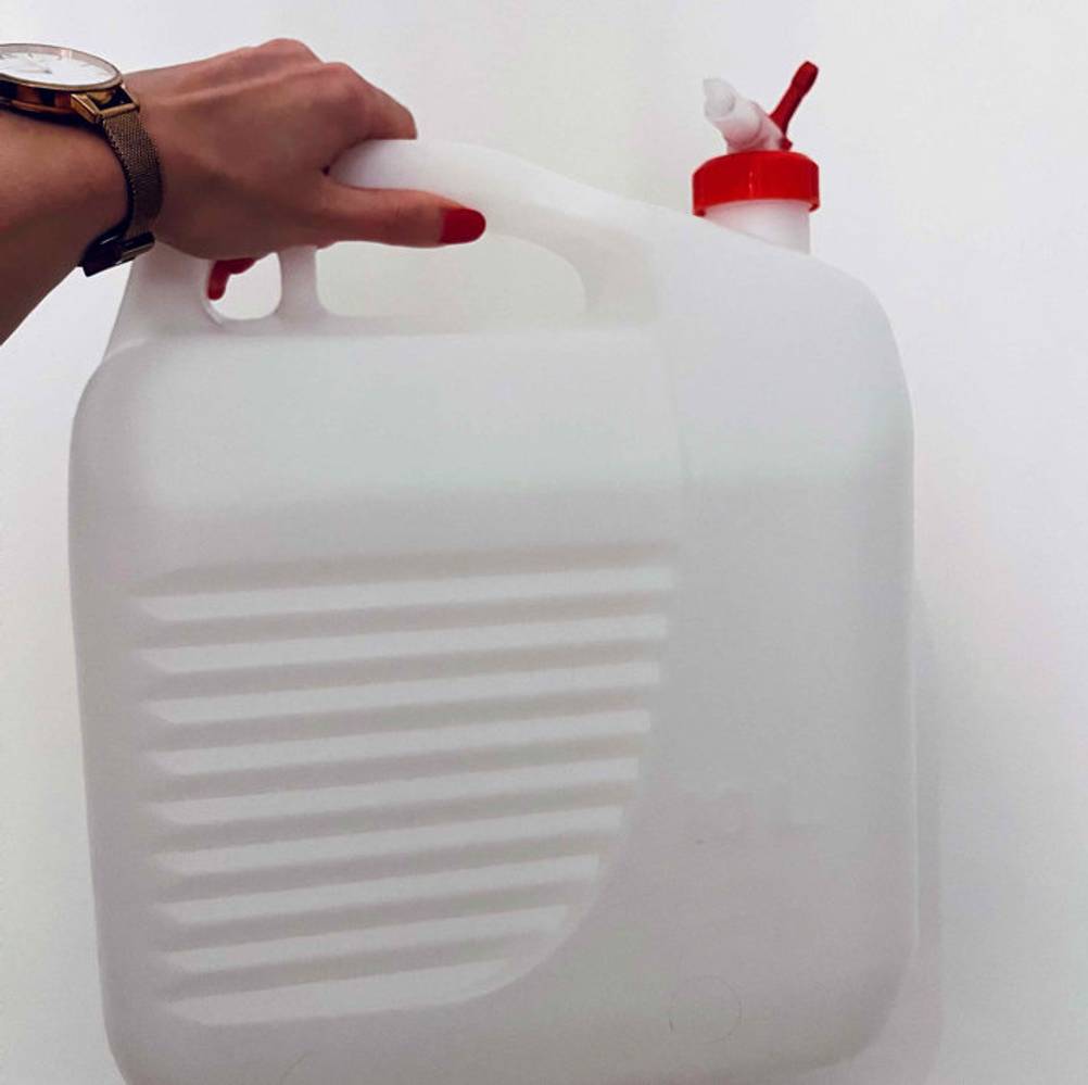 Wasserkanister getestet: weißer Wasserkanister wird vor eine weiße Wand gehalten.