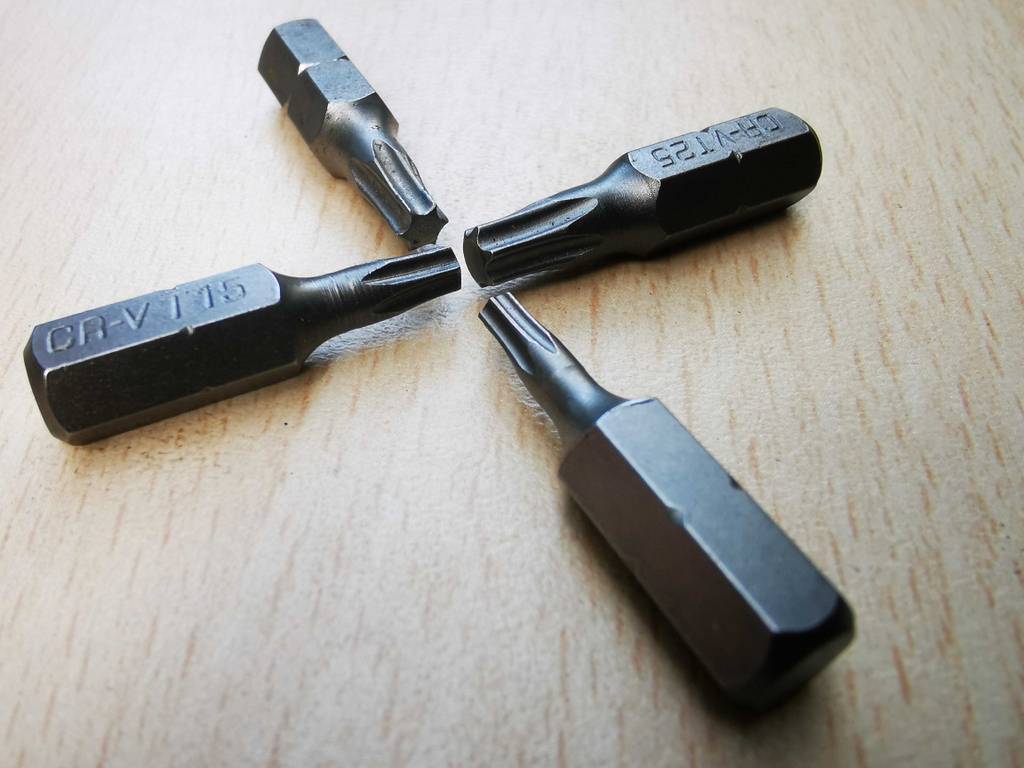 Im Test: Torx-Bits in unterschiedlichen Ausführungen liegen in Form eines Kreuzes auf einer weißen Oberfläche.