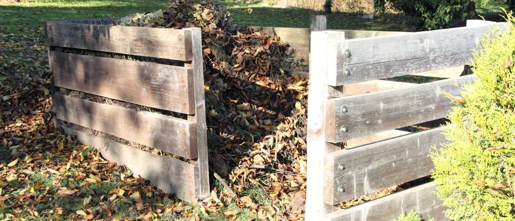 Holz-Komposter-Test: Ein Holz-Komposter im Garten gefüllt mit Laub.