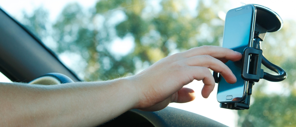 Auto-Handyhalterung-Test: Bedienung eines Smartphones, das sich in einer an der Frontscheibe befindlichen Handyhalterung befindet