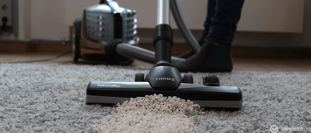 Ein getesteter Staubsauger ohne Beutel von Philips saugt Teppichboden.