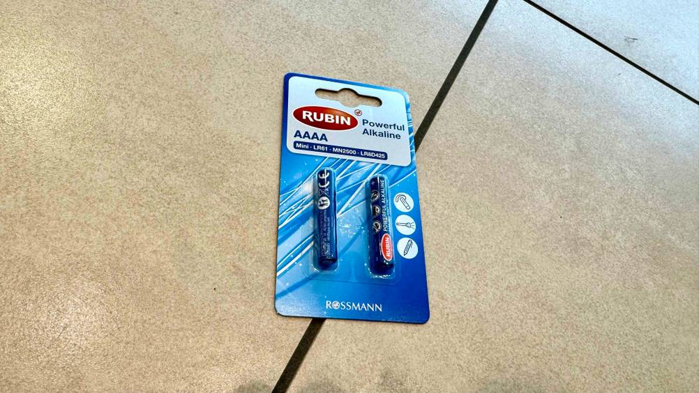 Auf einem Fließenboden befindet sich eine Packung der getesteten AAAA-Batterien.