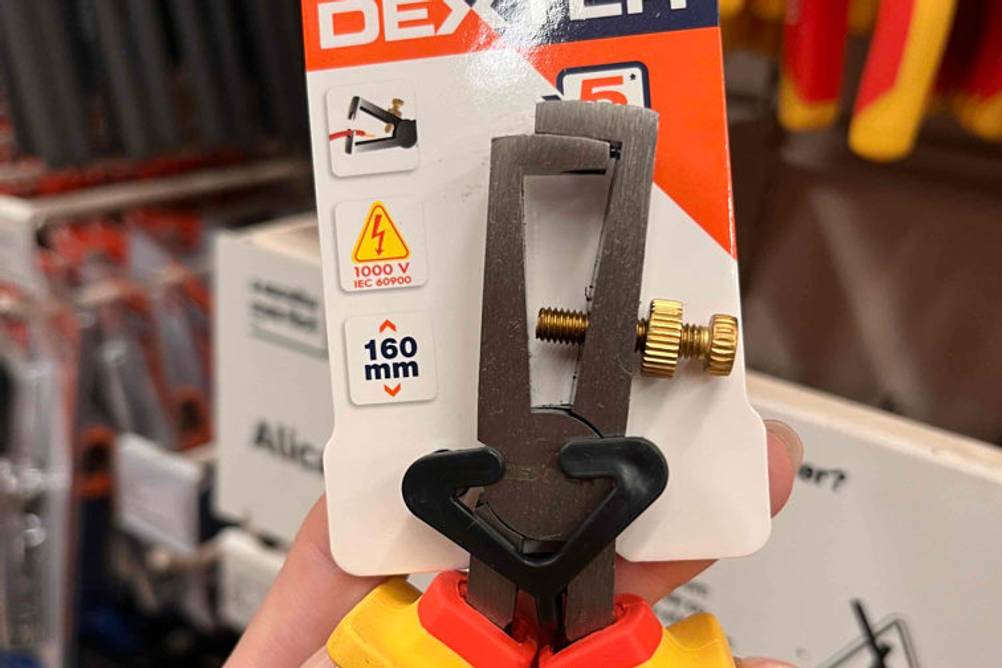 In der Hand befindet sich eine getestete Abisolierzange.