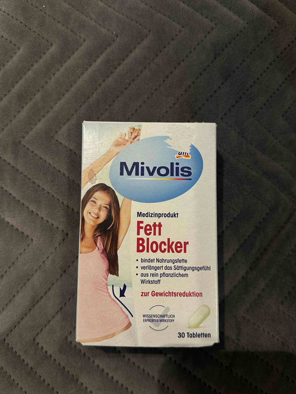 Abnehmpillen getestet: Eine Originalverpackung auf einer dunklen Stoffoberfläche.