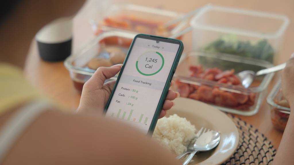 Eine Frau mit einer Abnehmprogramm-App dokumentiert ihr Essen.