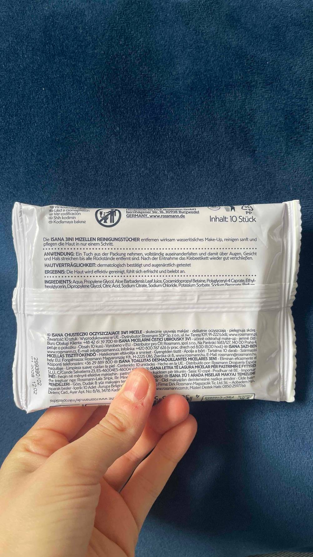 Abschminktücher-Test: Eine Hand hält die weiße 10-Stück-Kunststoffpackung mit rückseitiger Produktinformation in die Kamera.