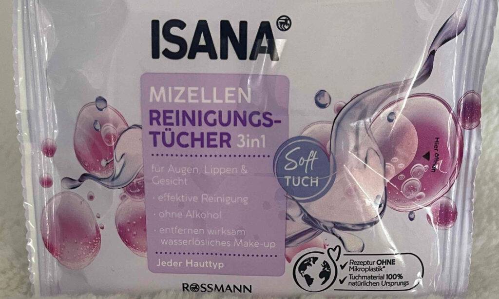 Die getesteten Abschminktücher befinden sich in der ISANA-Verpackung, die auf einem weißen Kissen liegt.