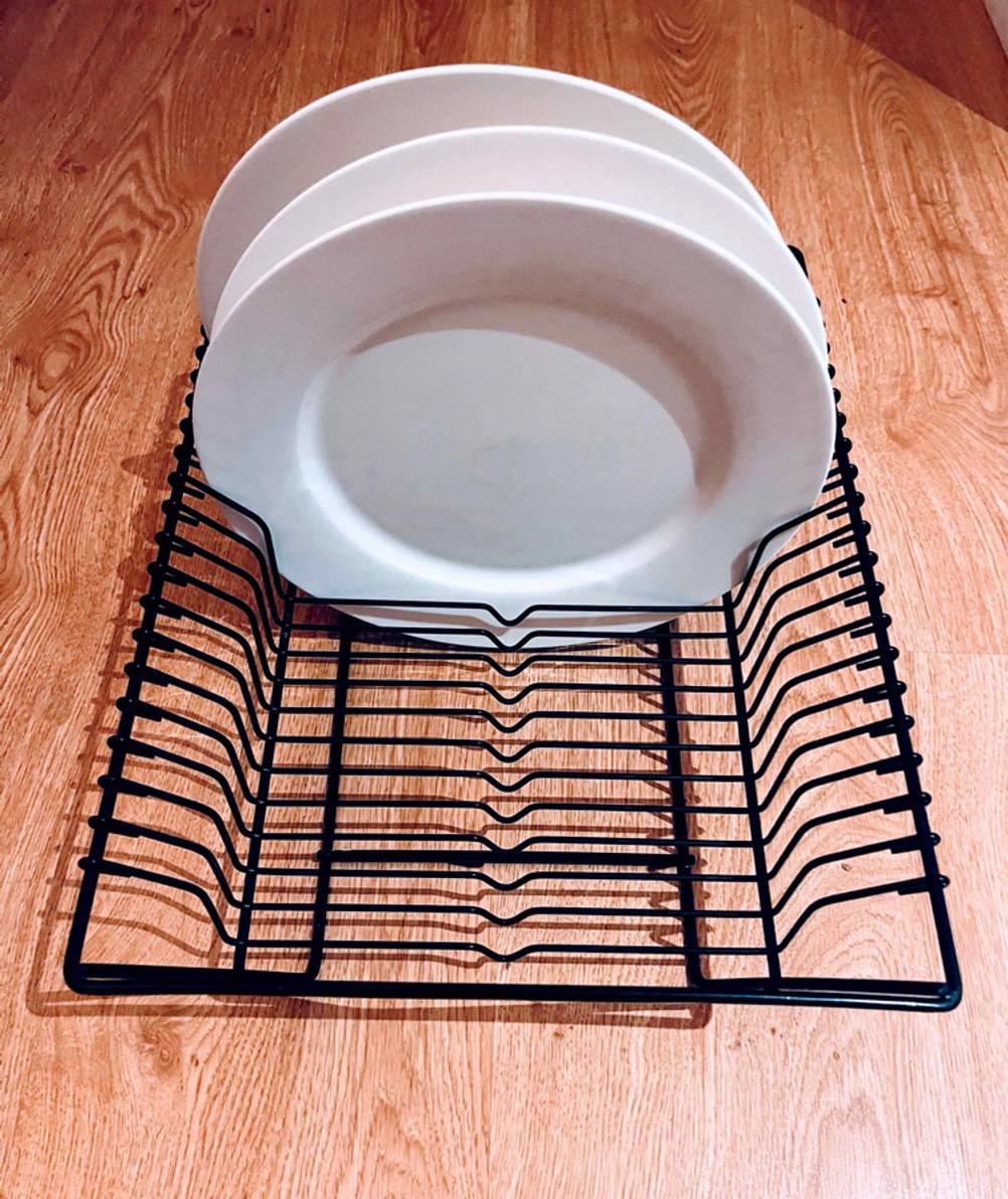 Im Test: Ein Abtropfgestell mit weißen Tellern von vorne auf einer Holzfläche.