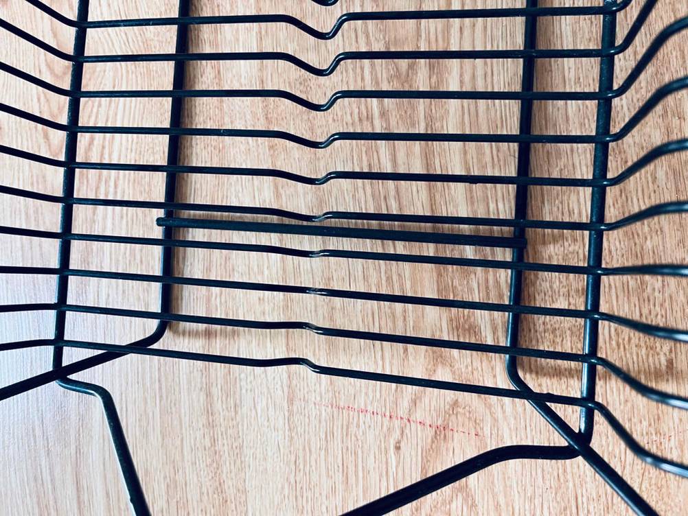 Nahaufnahme des Gestänges eines getesteten Abtropfgestells auf einem Holztisch.