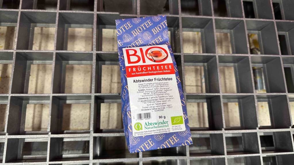 Ein getesteter Bio-Früchtetee liegt in einer 90-g-Packung auf einem Gitter.