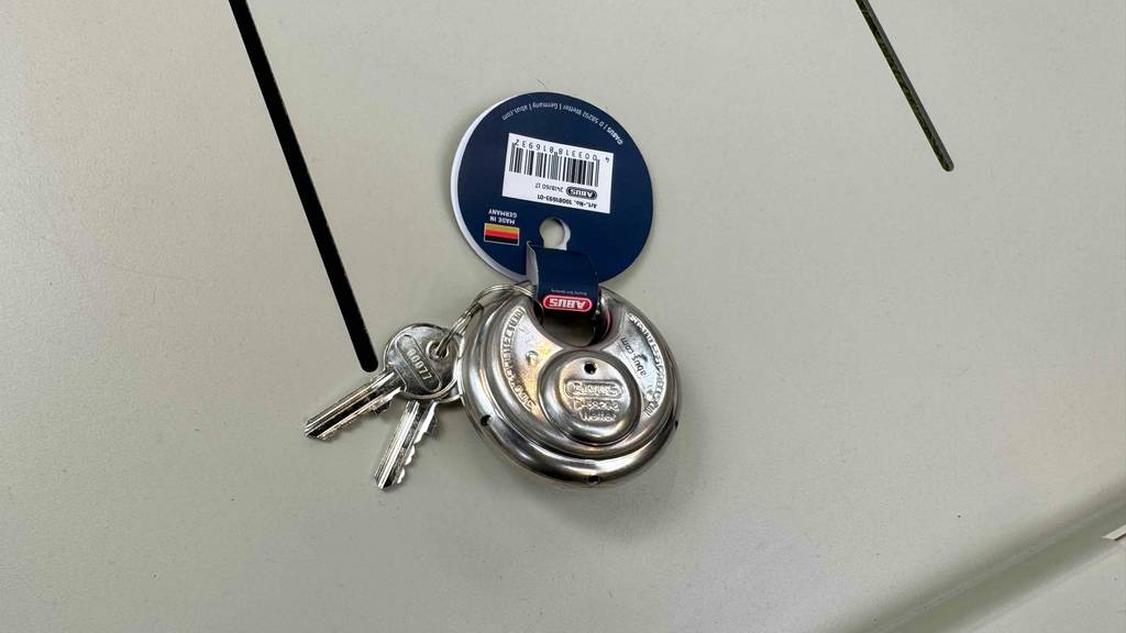 An einem Abus-Diskusschloss im Test ist ein Infoanhänger aus Pappe.