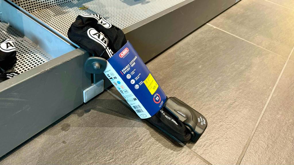 Ein E-Bike-Schloss im Test lehnt in der Verpackung an einem Verkaufsregal.