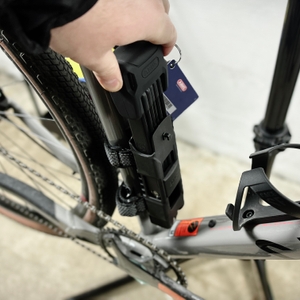 Das Abus Bordo 6000K wird zur Hälfte aus der Halterung gezogen. Der Rahmen des Fahrrads ist im Hintergrund sichtbar.