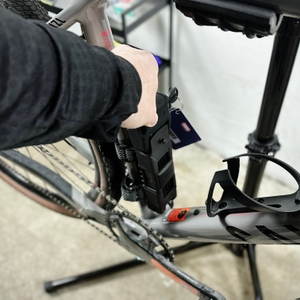 Das Abus Bordo 6000K wird aus der Halterung gezogen. Die Bewegung beginnt am unteren Ende des Fahrradrahmens.