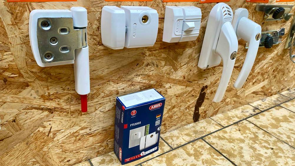 Fenstersicherung getestet: An einem Holzbrett sind mehrere Produkte befestigt inklusive der Fenstersicherung.