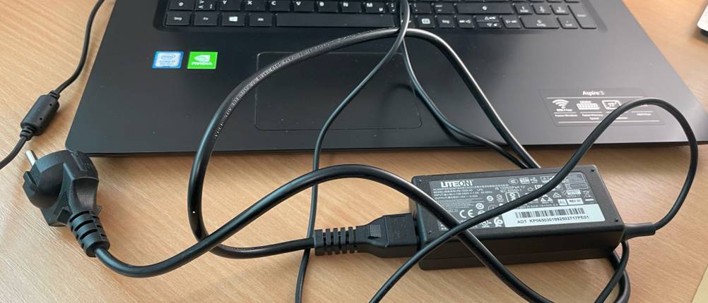 Vor einem getesteten Acer Aspire liegt das Ladekabel.