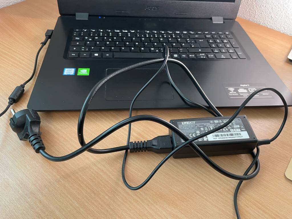 Vor einem getesteten Laptop bis 1000 Euro liegt das Stromkabel.