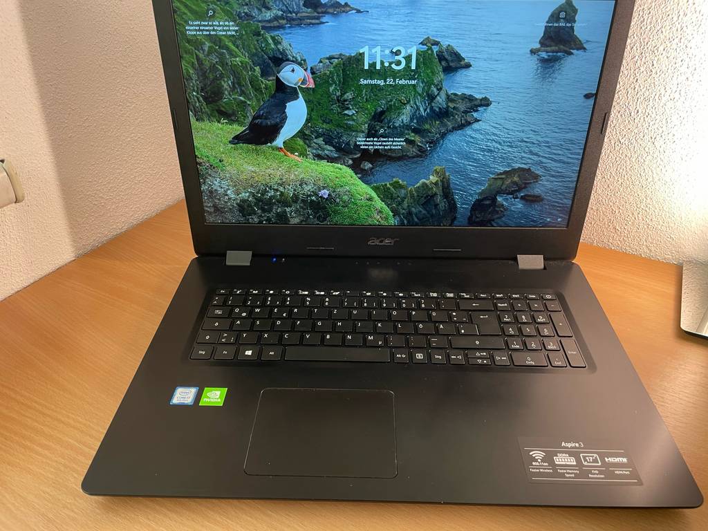 Laptop bis 1000 Euro im Test: Ein Gerät steht eingeschaltet auf einem Holztisch.