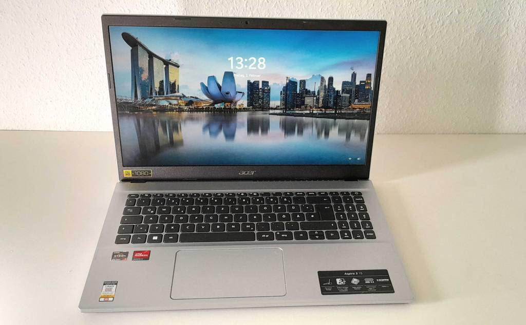 Ein silberfarbener und eingeschalteter Laptop mit 8 GB RAM und 512 GB SSD im Test mit mattem Display befindet sich auf einem weißen Tisch.