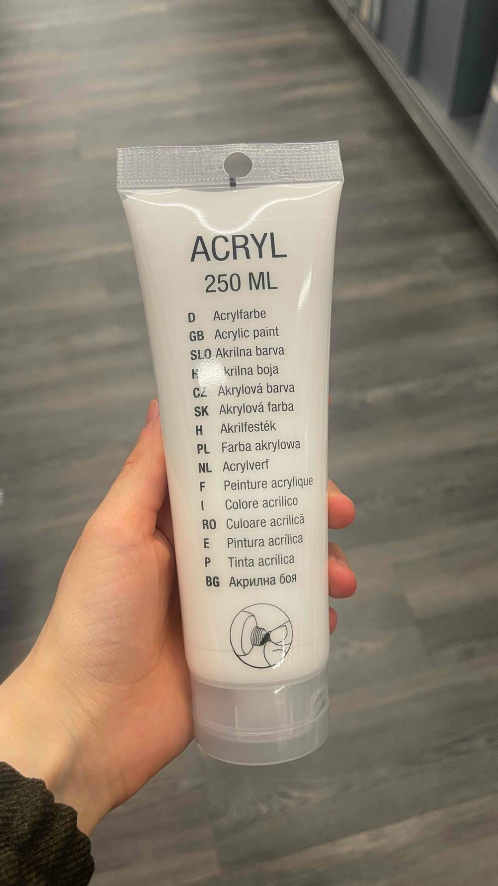 Acrylfarben getestet: Eine Hand hält eine Tube in weiß mit 250 ml Inhalt.