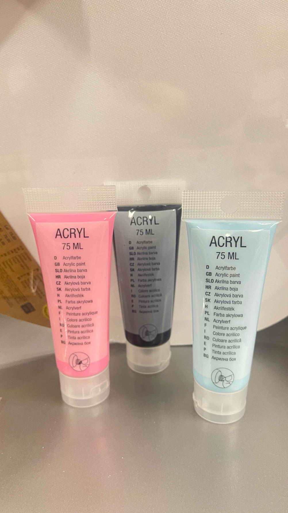 Acrylfarben-Test: Mehrere Tuben stehen vor einer weißen Wand.