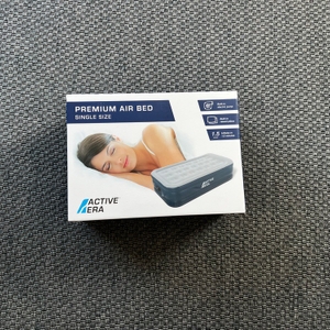 Der Karton der Active Era AB-S1-EU liegt auf einem Teppich.