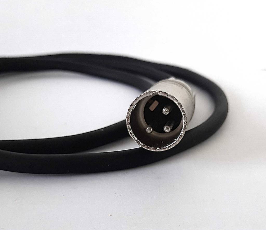 Ansicht eines dreipoligen, versilberten Steckers am schwarzen, getesteten Audiokabel vor einem weißen Hintergrund.