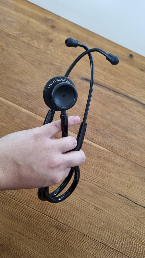 Ein Stethoskop in der Hand einer Person.
