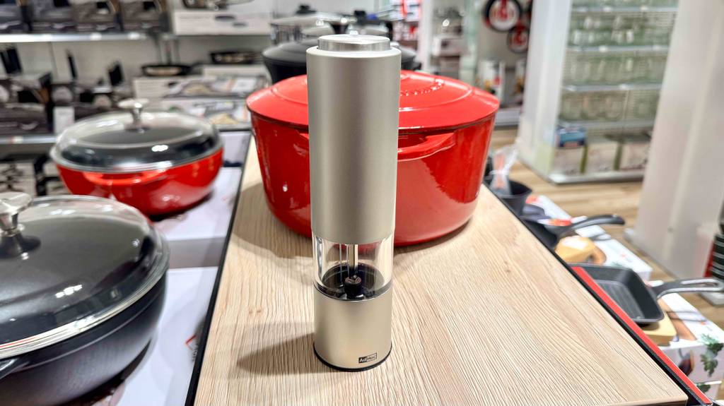 Eine AdHoc-Pfeffermühle steht getestet vor einem roten Kochtopf.