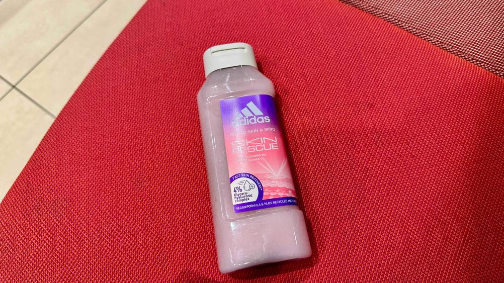 Adidas-Duschgel im Test: Eine Flasche liegt auf einer roten Fläche.