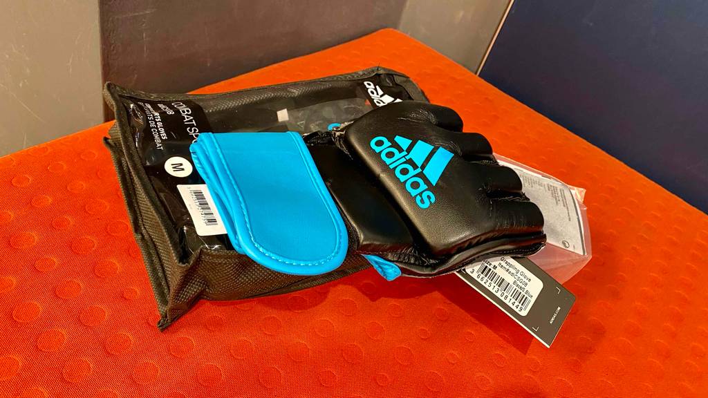 Im Test: Ein MMA-Handschuh auf seiner Verpackung auf einer roten Fläche.