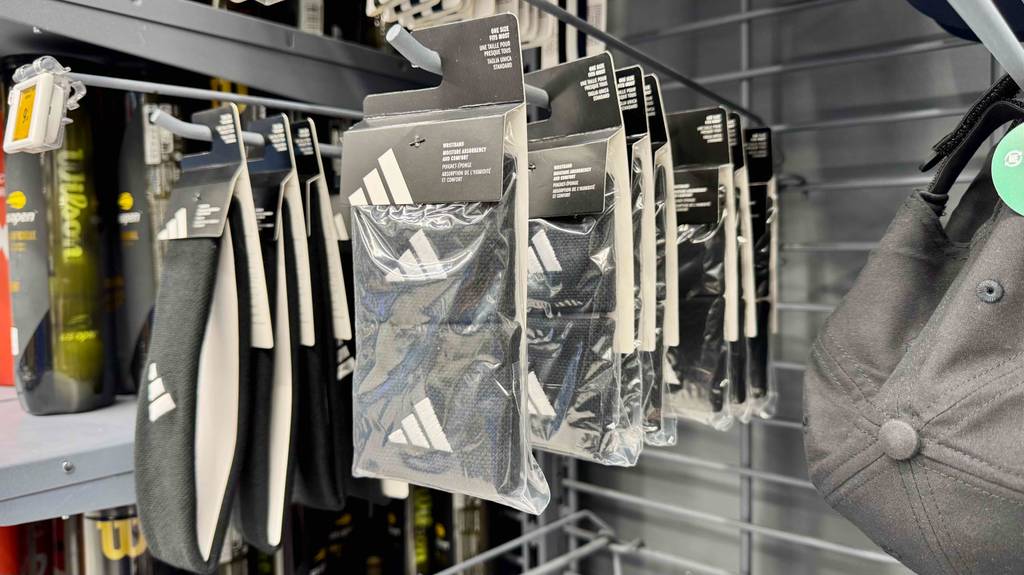 Mehrere verpackte Schweißbänder hängen zum testen in einem Hängeregal.