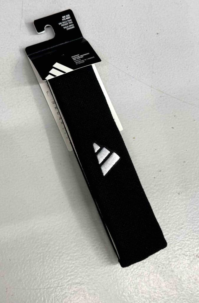 Stirnbänder im Test: Ein schwarzes Modell inklusive Etikett liegt auf einer hellgrauen Oberfläche.