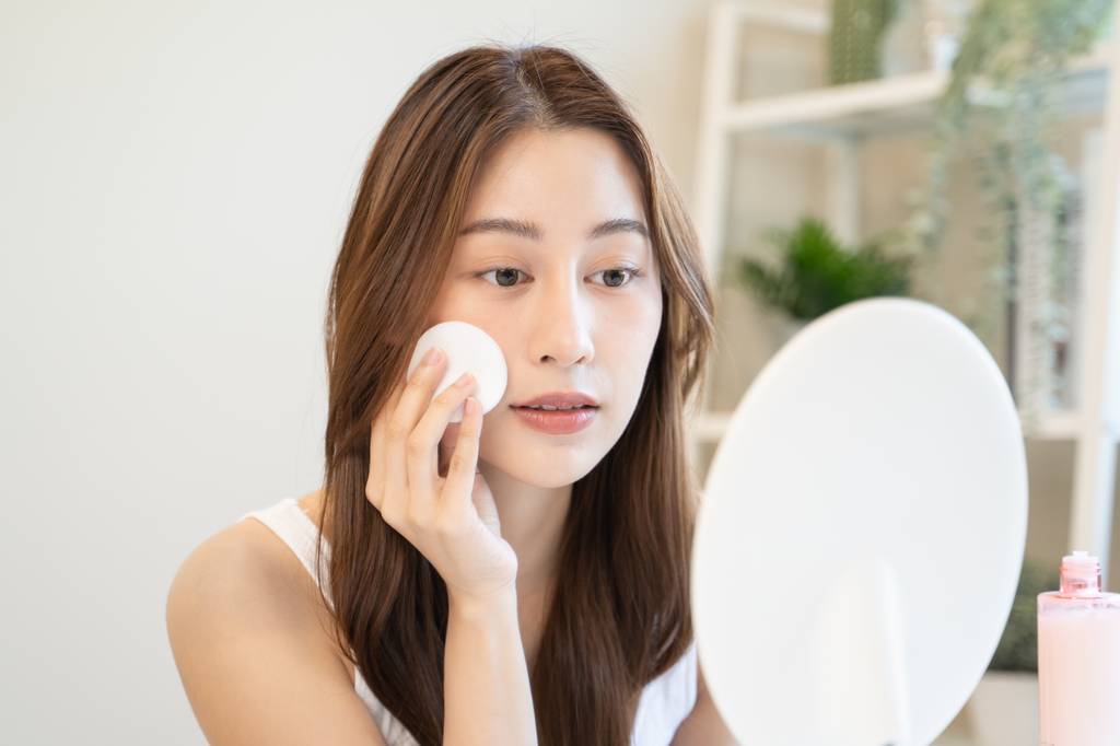 Peeling-Pads-Test: Eine Frau streicht sich mit dem Wattepad über das Gesicht.
