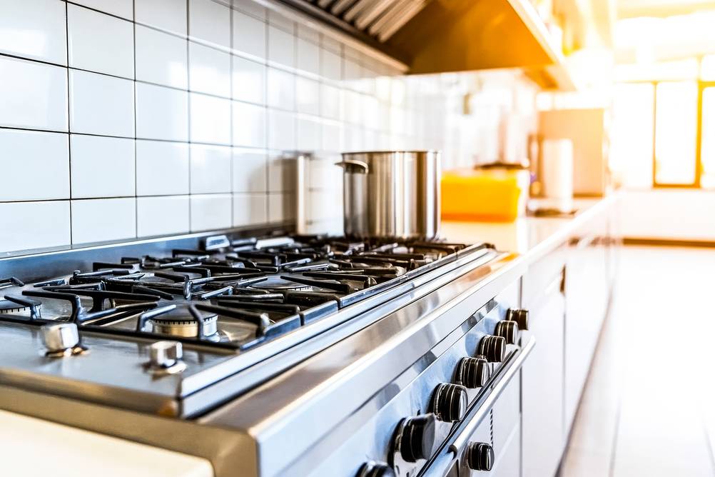Gaskochfeld 5-flammig Test: in einer Gastroküche – Ein großer Topf steht daneben.