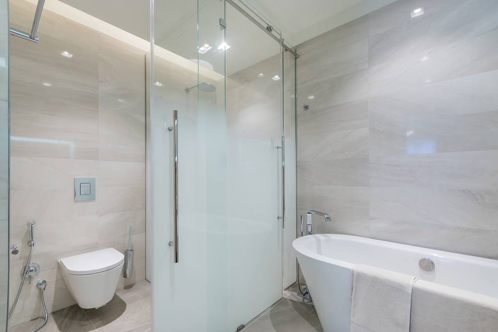 Glasschiebetür im Test: Ein Badezimmer mit durch Glas getrennte Bereiche mit einer Schiebetür zum Bereich der Toilette.